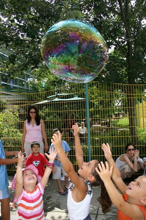 Children chase a giant bubble during Bubble Blowout at Providence Children's Museum.